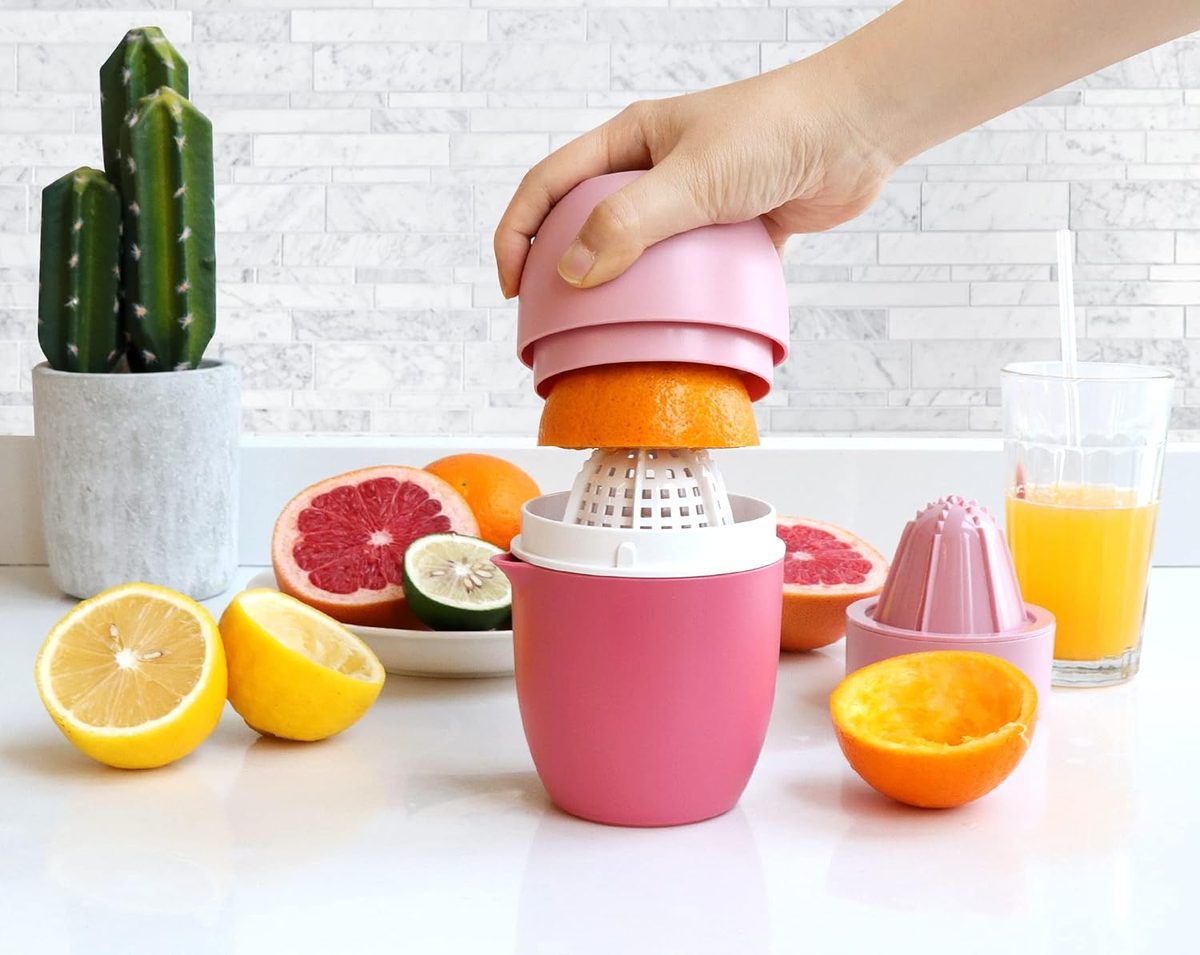 Pressing an orange half in the pink juicer